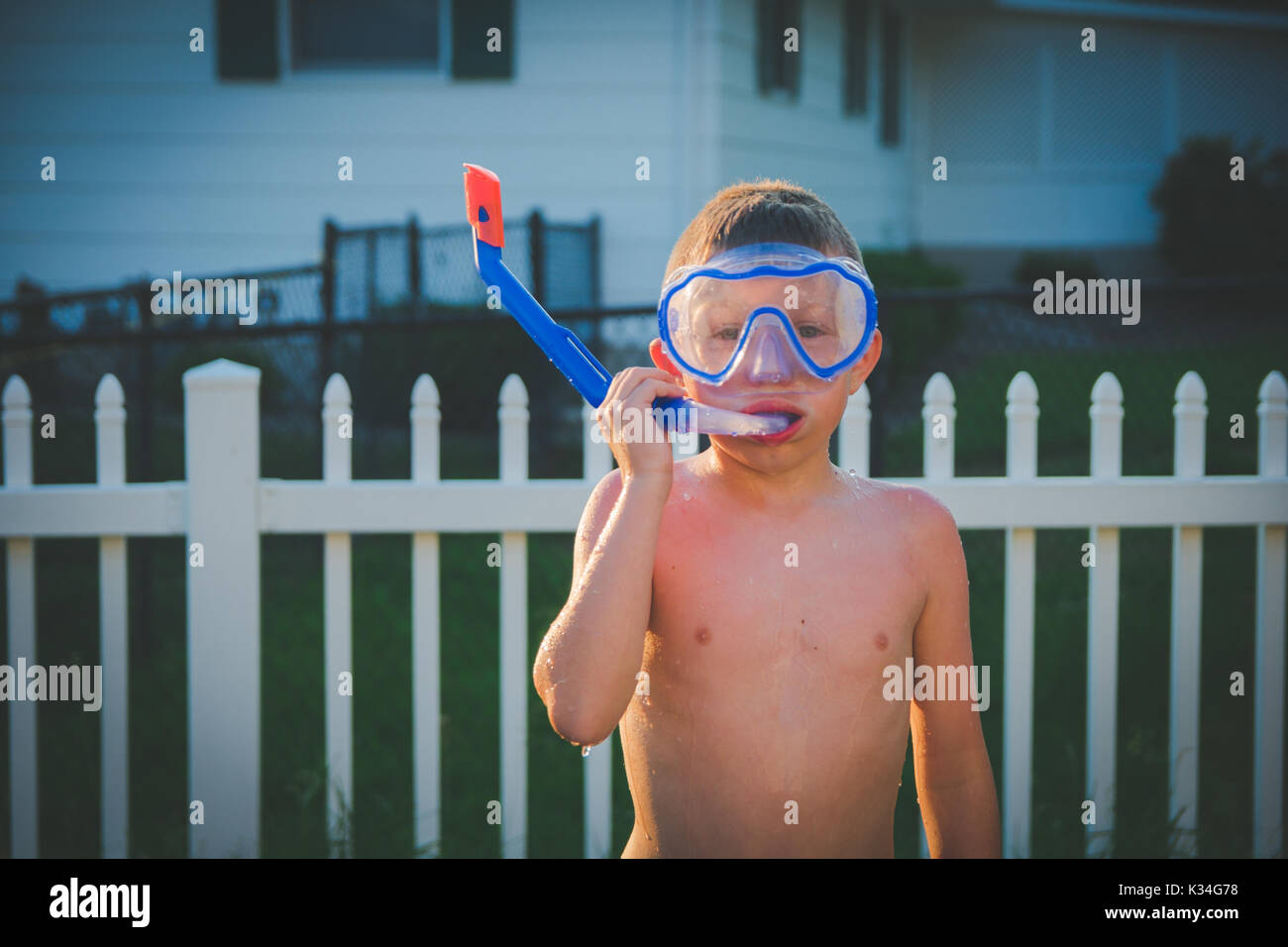 Ein Junge trägt eine scuba Maske in einem Hinterhof im Sommer. Stockfoto