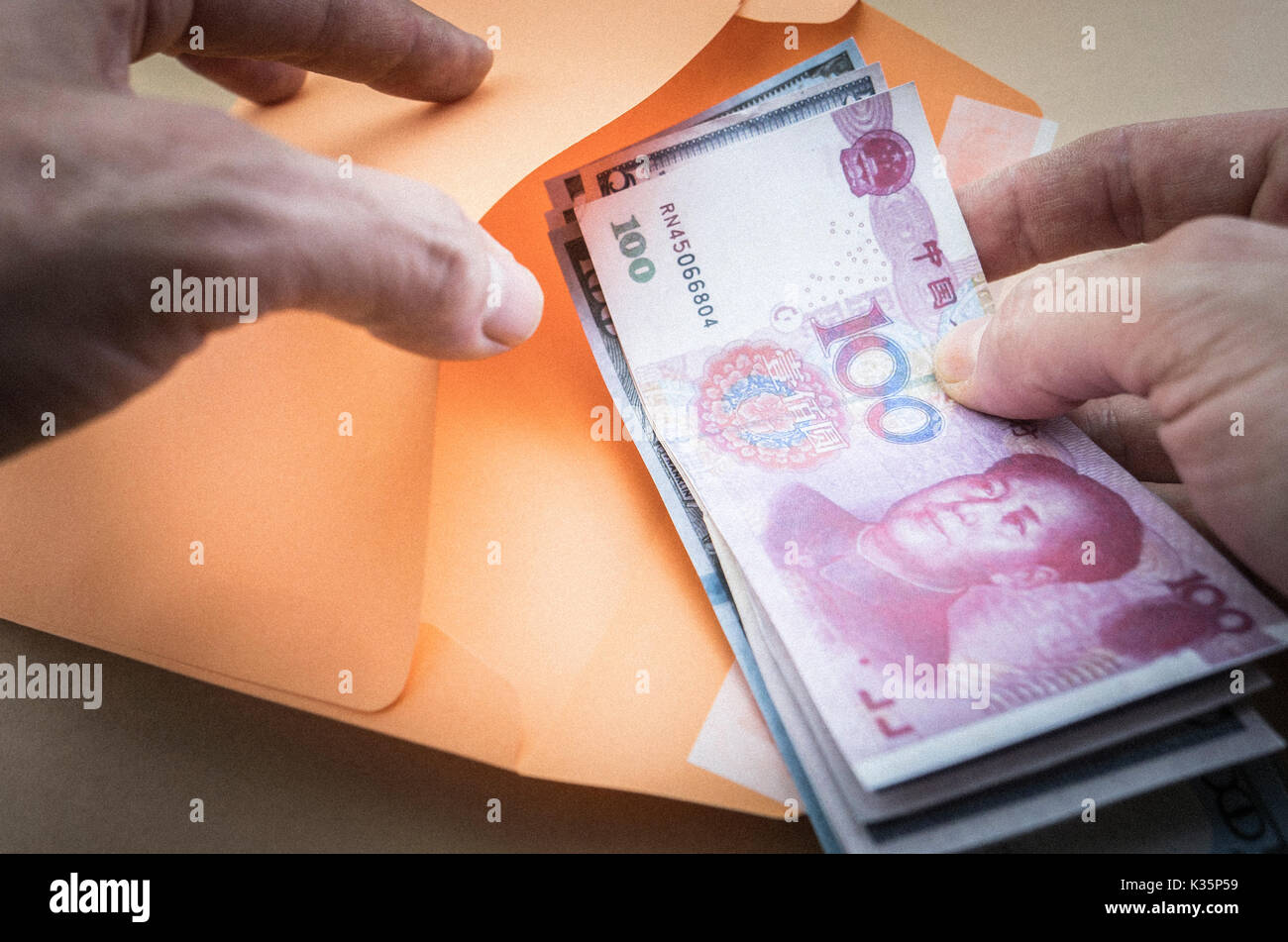 Man führt mehrere Tickets für eine ausländische Währung in einem Umschlag an Orange Farbe, Business Konzept Stockfoto