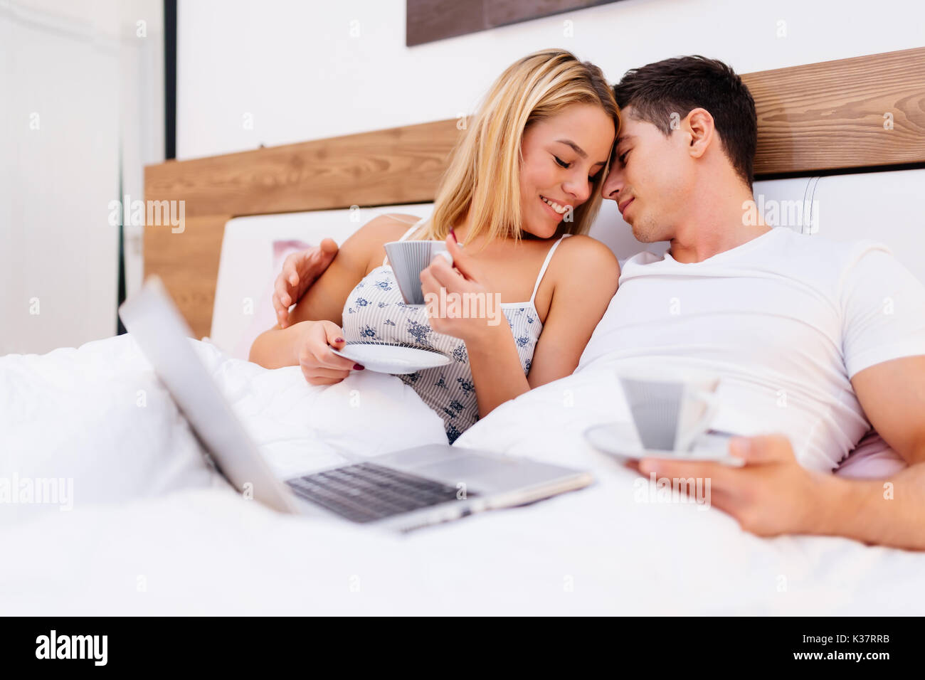 Verliebtes Paar holding Kaffee, während im Bett Stockfoto