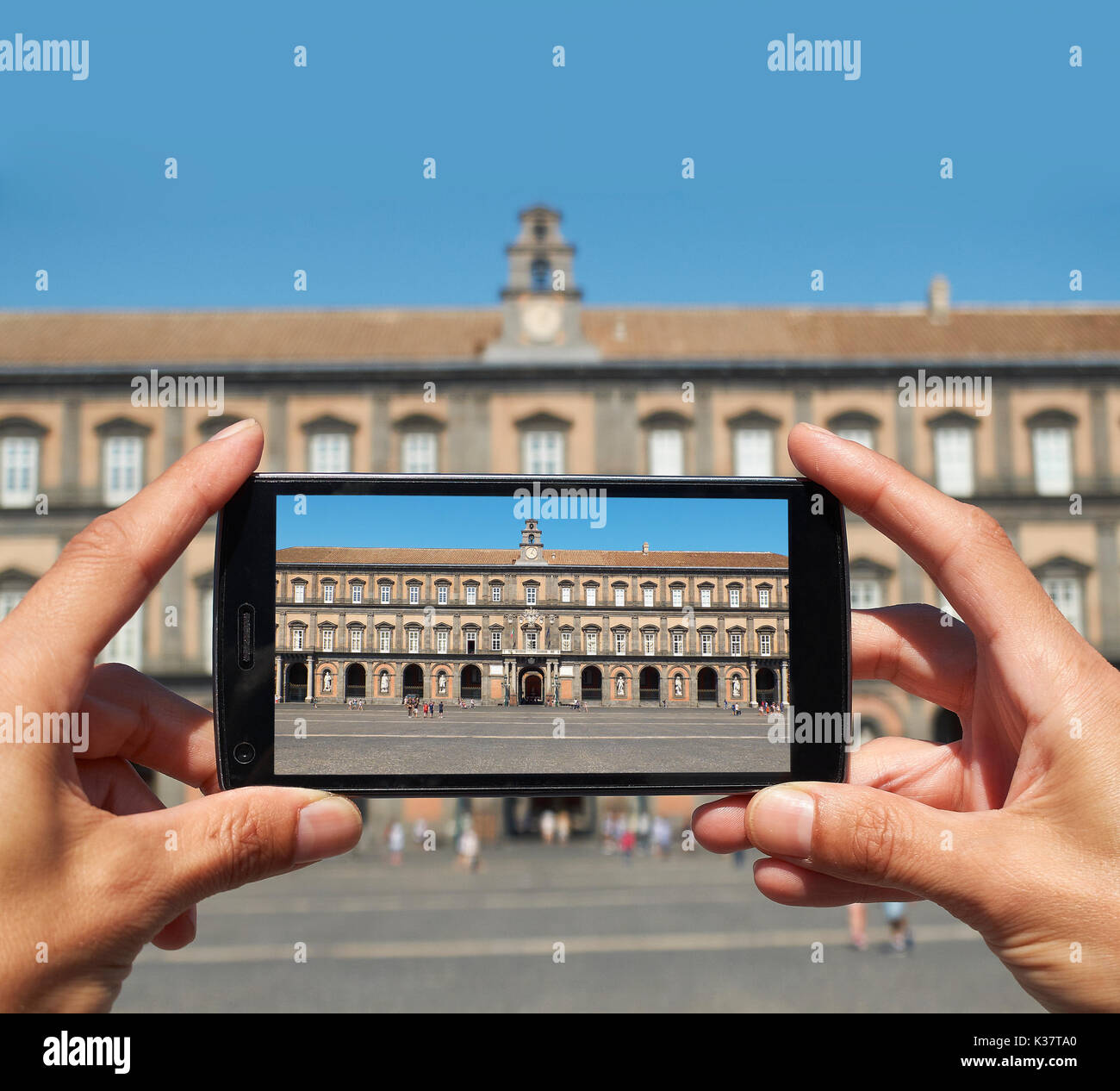 Junge männliche Hände nehmen ein Foto von der Palazzo Reale di Napoli (principal Fassade) auf der Piazza del Plebiscito. Neapel. Kampanien, Italien. Stockfoto