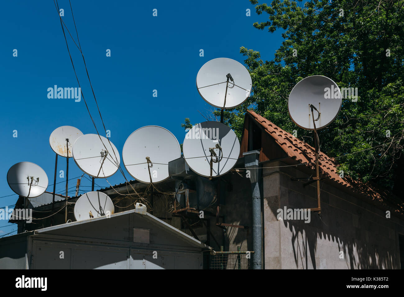 Viele Satellitenschüsseln auf dem Dach des Hauses. Stockfoto