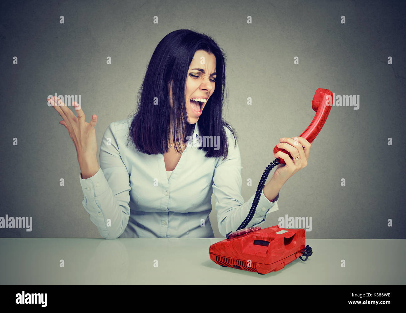 Zornige junge Frau schreiend auf dem Telefon Stockfoto