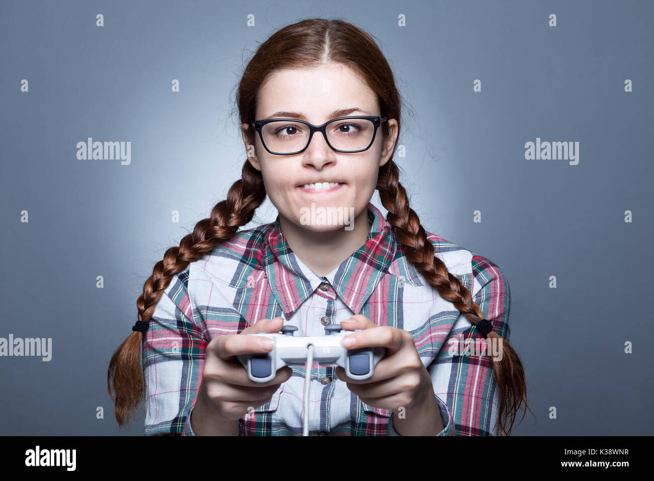 Nerd Frau mit Zopf Videospiele spielen mit einem Joypad Stockfoto