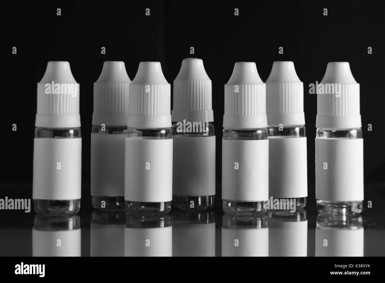 E liquid Flaschen für vaping Geräte, e Zigarette, elektronische Zigarette, über einem schwarzen Hintergrund. Stockfoto