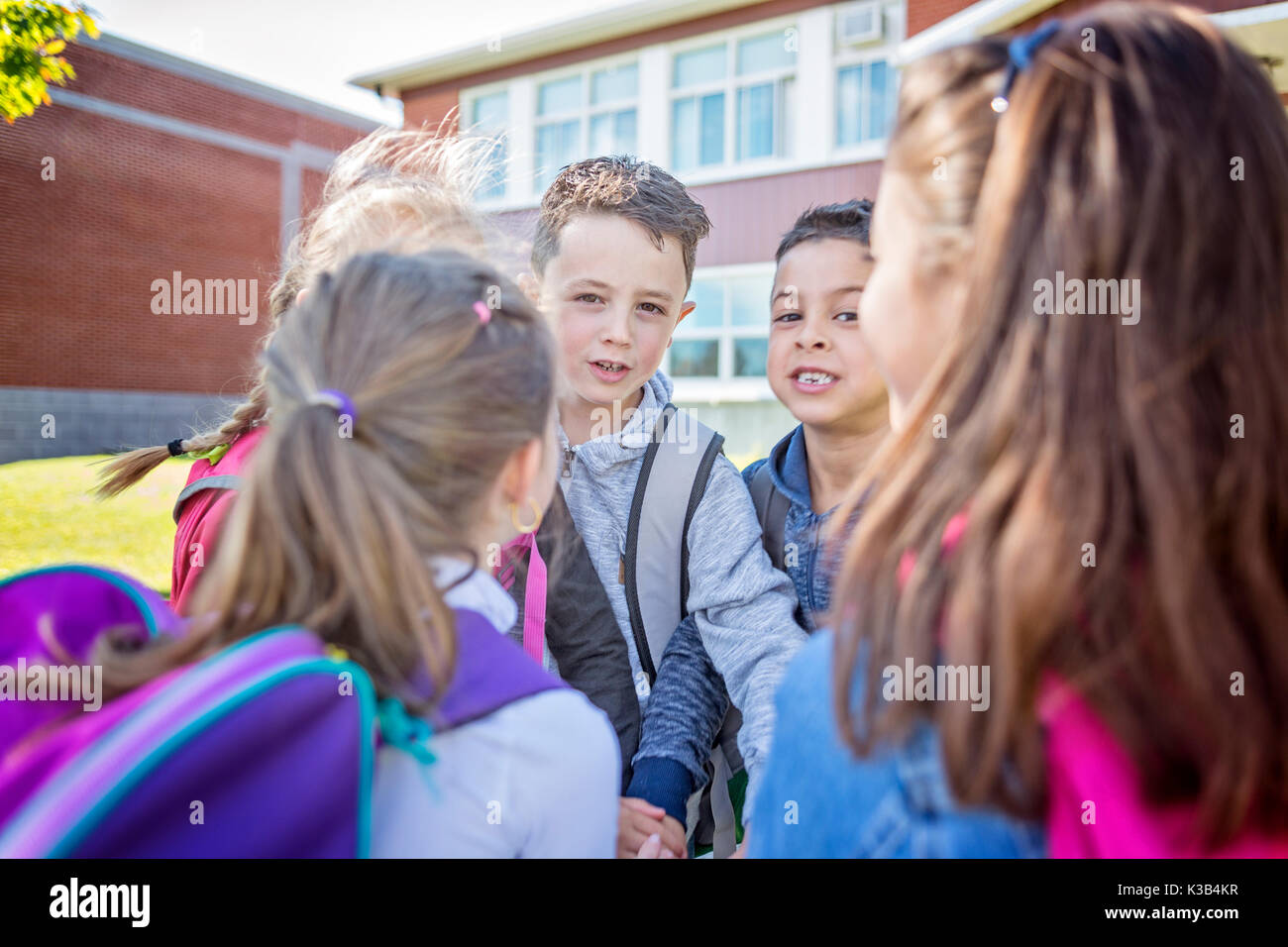 Die Schüler außerhalb der Schule stehen zusammen Stockfoto