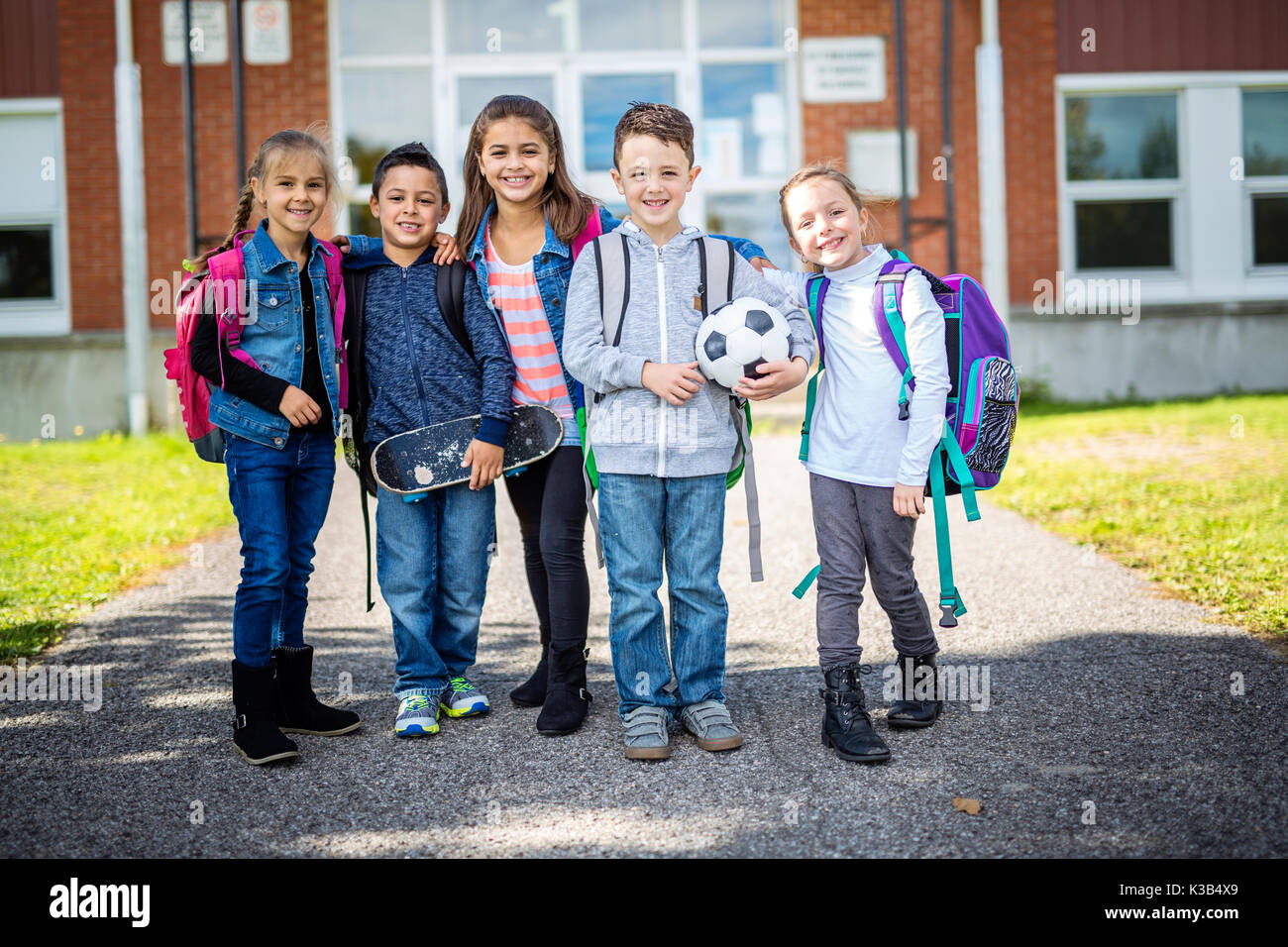 Die Schüler außerhalb der Schule stehen zusammen Stockfoto