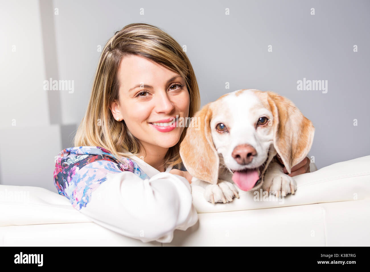 Schöne blonde junge Frau mit ihrem Hund zu Hause Stockfoto