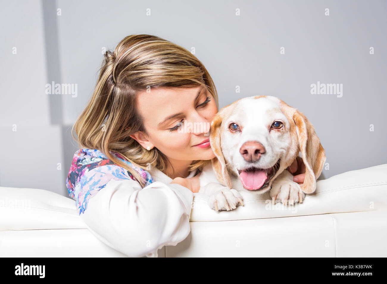 Schöne blonde junge Frau mit ihrem Hund zu Hause Stockfoto