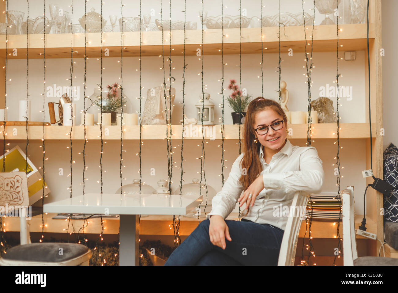 Young Business Frau sitzt am Tisch im eigenen Cafe. Stockfoto