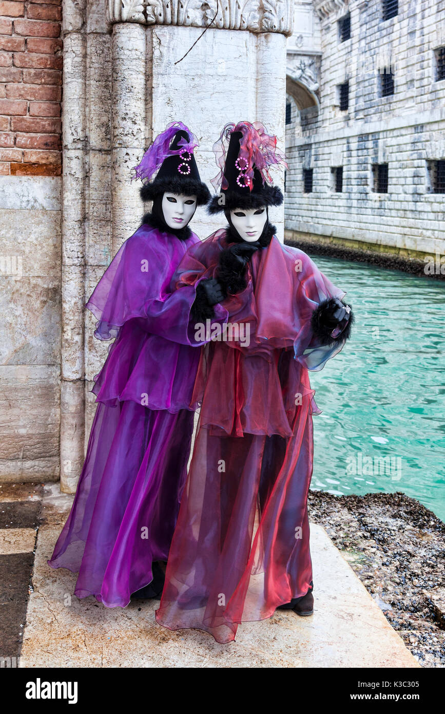 Venedig, Italien - 18 Februar 2012: Zwei Personen tragen bestimmte Kostüme und Masken in der Nähe von einem kleinen Kanal in Venedig im Karneval Tage posieren. Stockfoto