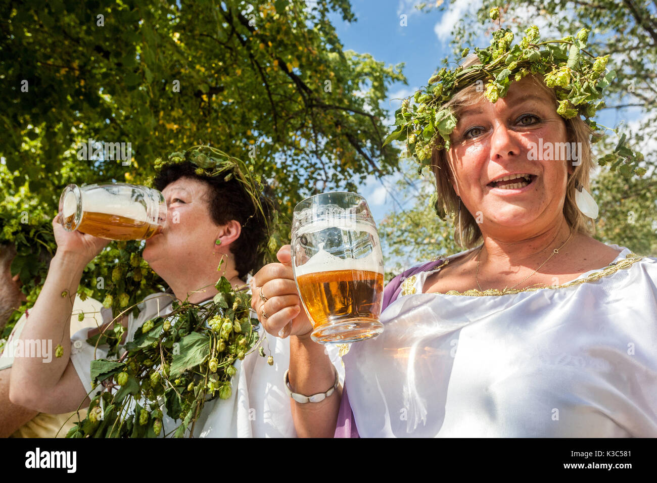 Die Göttin des Hopfens besuchte und eröffnete das tschechische Bierfest. Frau, die Bier trinkt, tschechische Bierfrauen dekoriert mit Hopfenkranz, Bierpflanze Stockfoto