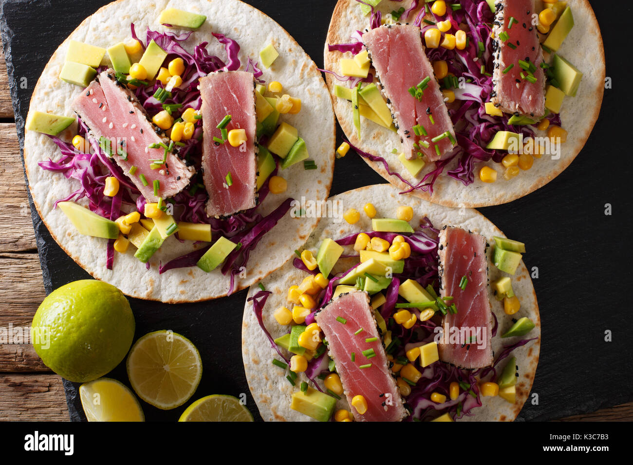 Mexikanische Tacos mit Thunfisch, Rotkohl, Mais, Avocado und Zwiebeln close-up auf den Tisch. Draufsicht von oben horizontal Stockfoto