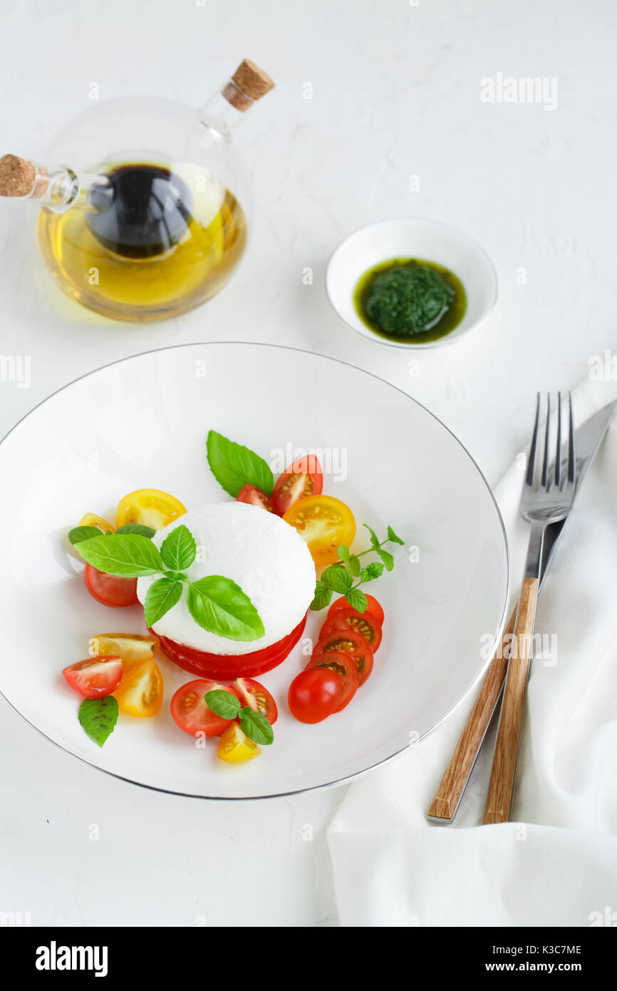 Caprese Salat mit reifen Tomaten und Mozzarella mit frischem Basilikum Blätter auf weißem Hintergrund. Ansicht von oben. Stockfoto