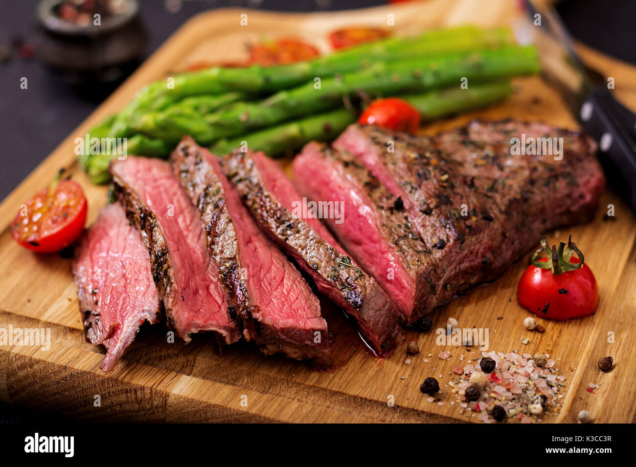 Saftiges steak selten Rindfleisch mit Gewürzen auf einem Holzbrett und ...