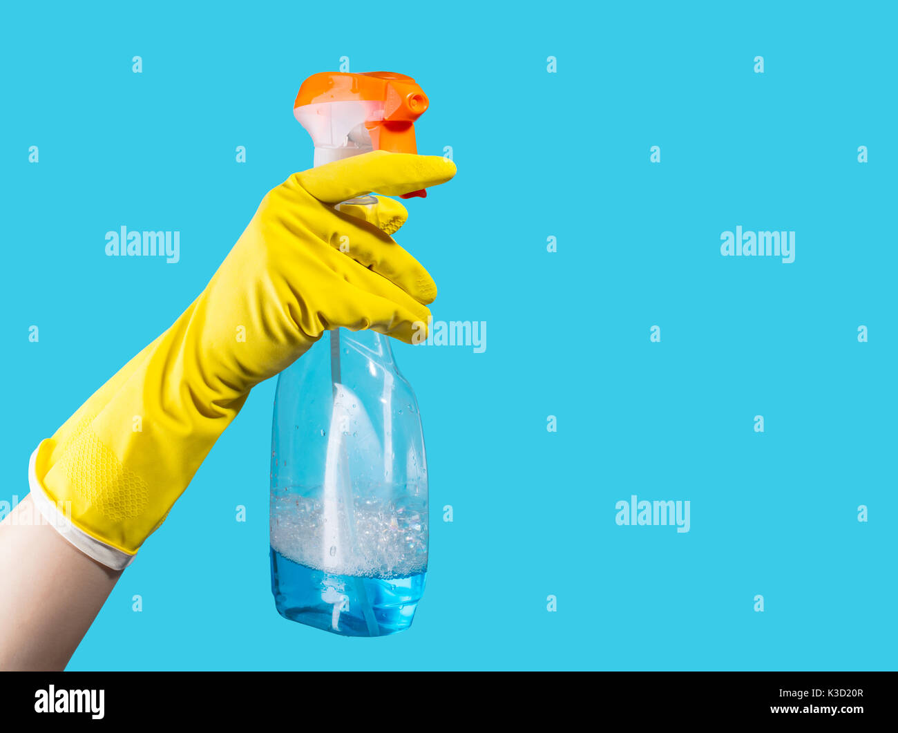Reinigungsmittel für die Reinigung in weiblicher Hand auf blauem Hintergrund Stockfoto