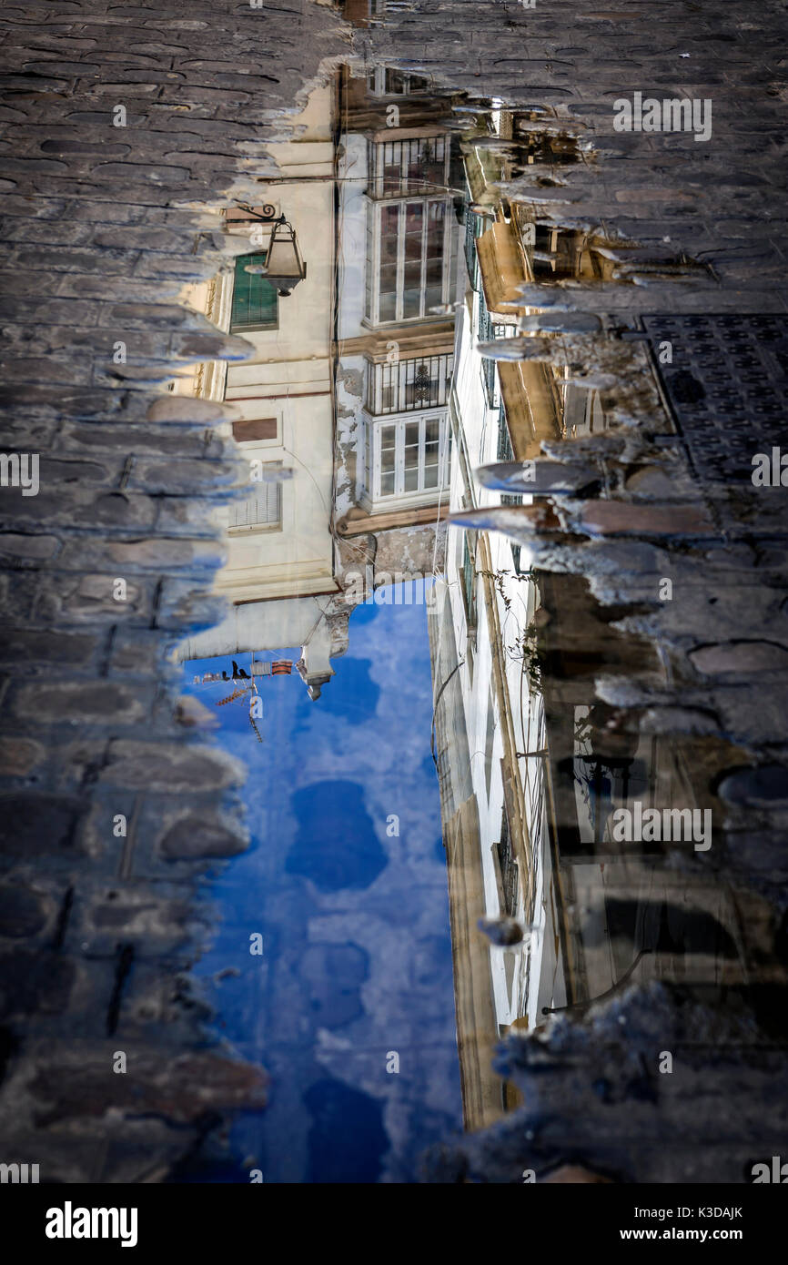 Gebäude in einer Pfütze auf der Straße, Andalusien, Spanien wider Stockfoto