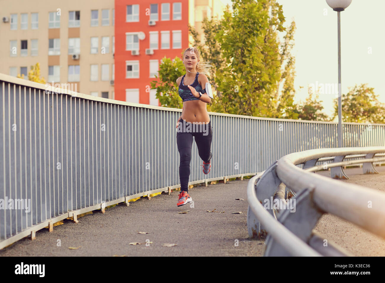 Ein Mädchen runner läuft auf einer Brücke in der Stadt im Herbst Sommer. Stockfoto