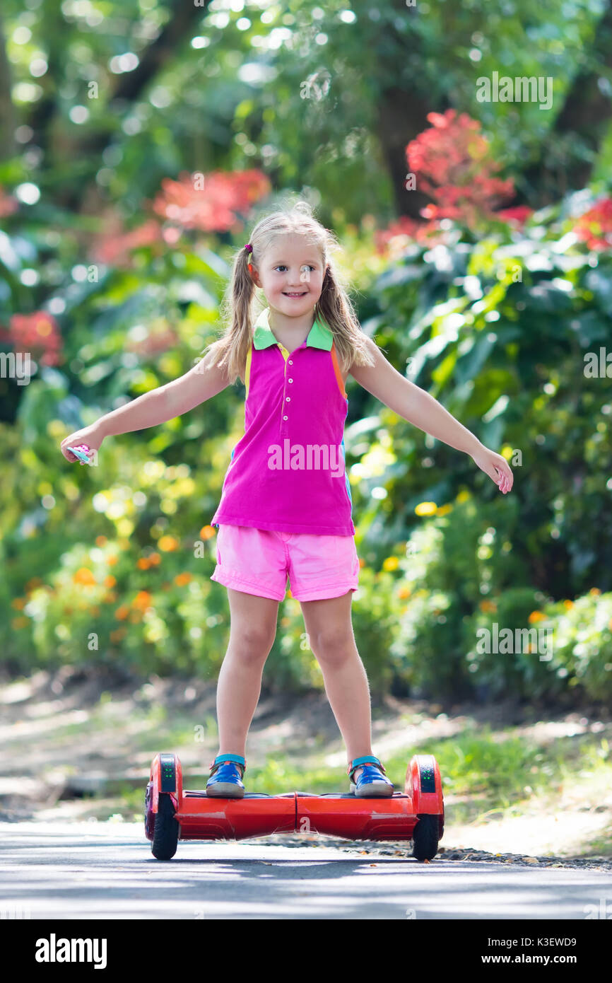 Kind auf hover Board. Kinder reiten Roller im Sommer Park. Balance Board  für Kinder. Elektrische selbst balancing Roller auf der Straße der Stadt.  Mädchen lernen Stockfotografie - Alamy