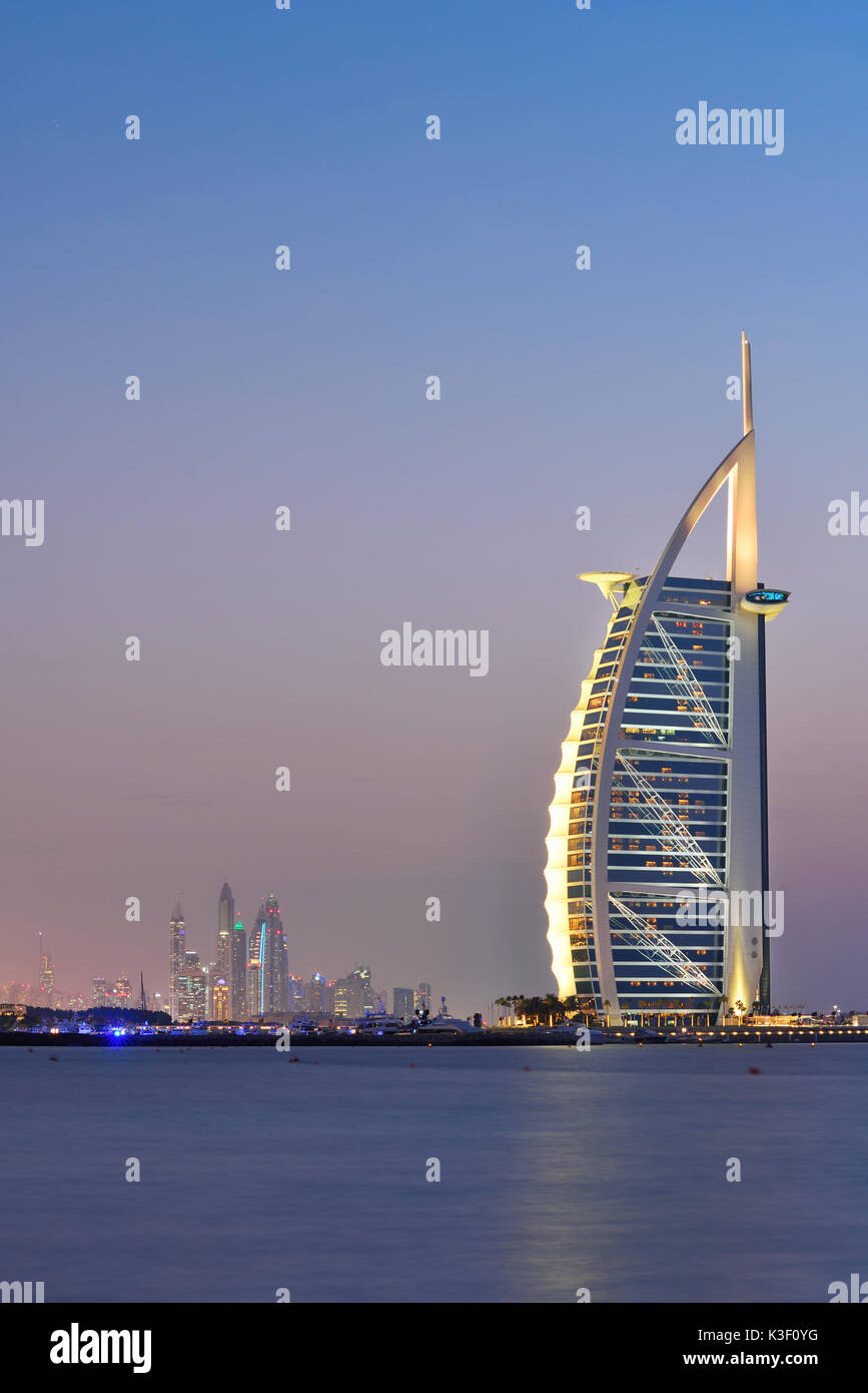 Dubai, Vereinigte Arabische Emirate - 10.Oktober 2016: Die beleuchteten Burj Al Arab Hinweis und in der Abenddämmerung marinal, Ansicht von Jumeira Beach, nach Südwesten. Stockfoto