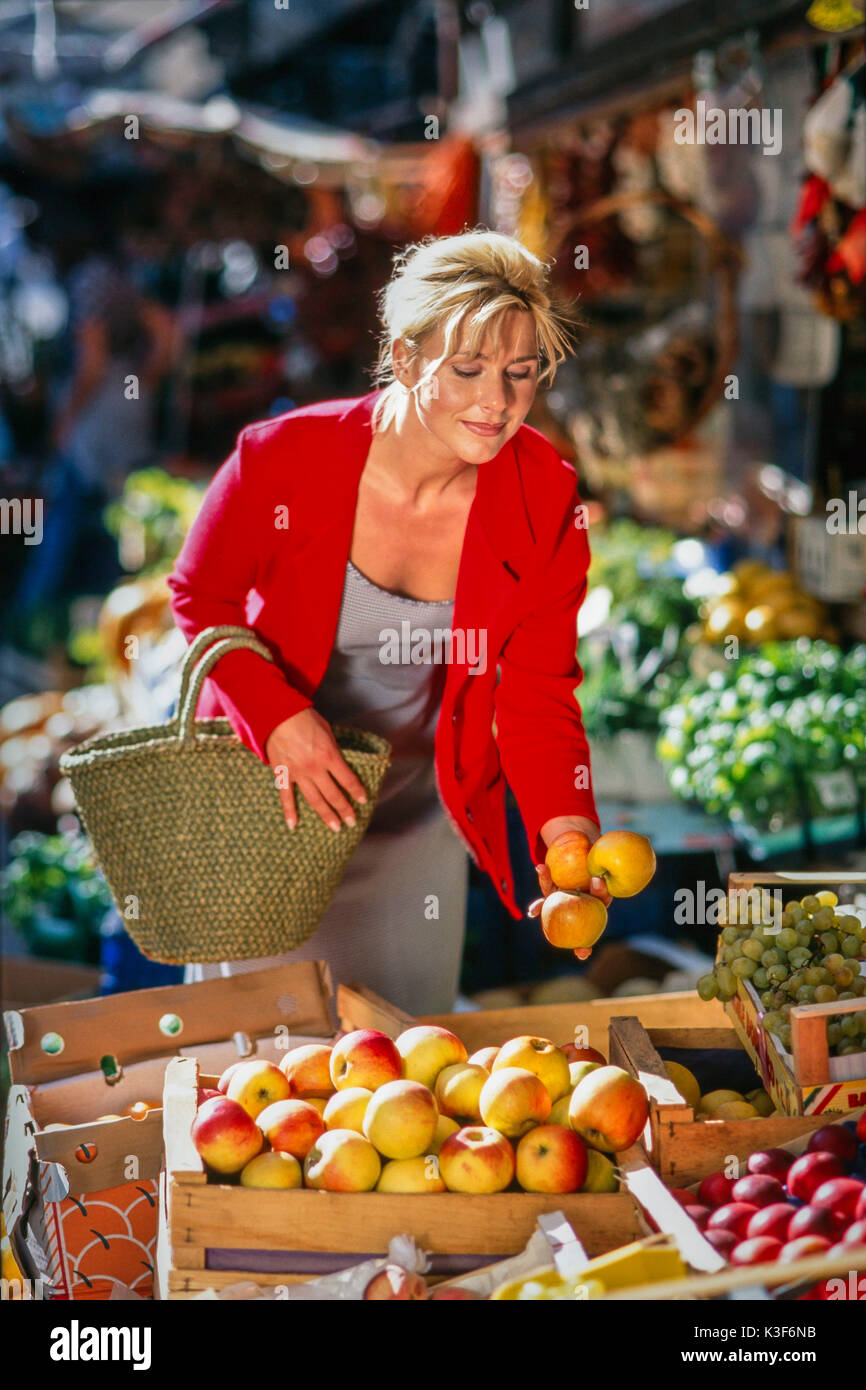 Junge Frau kauft Äpfel auf dem Markt in Stockfoto