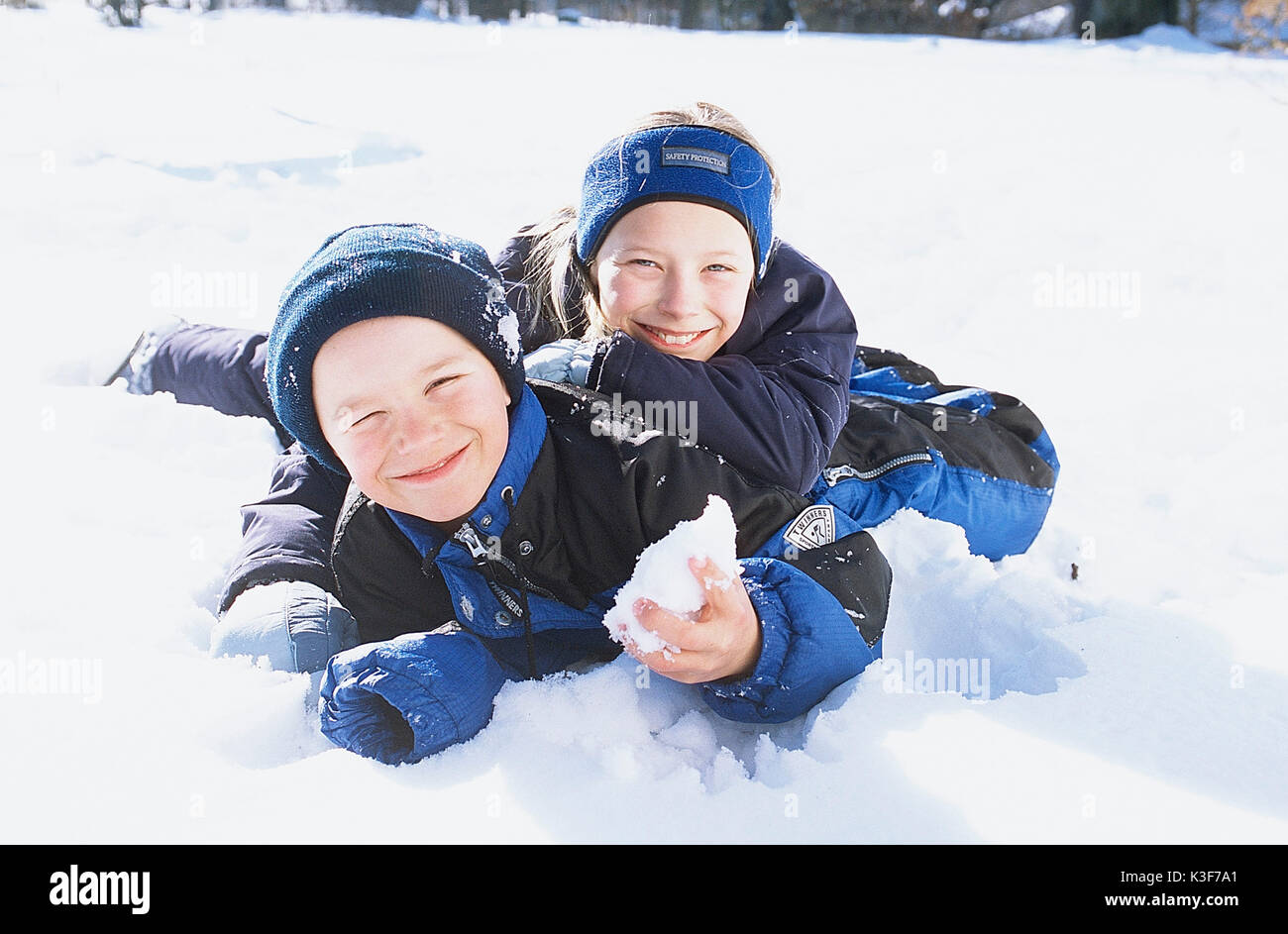 Mädchen und Jungen spielen im Schnee Stockfoto