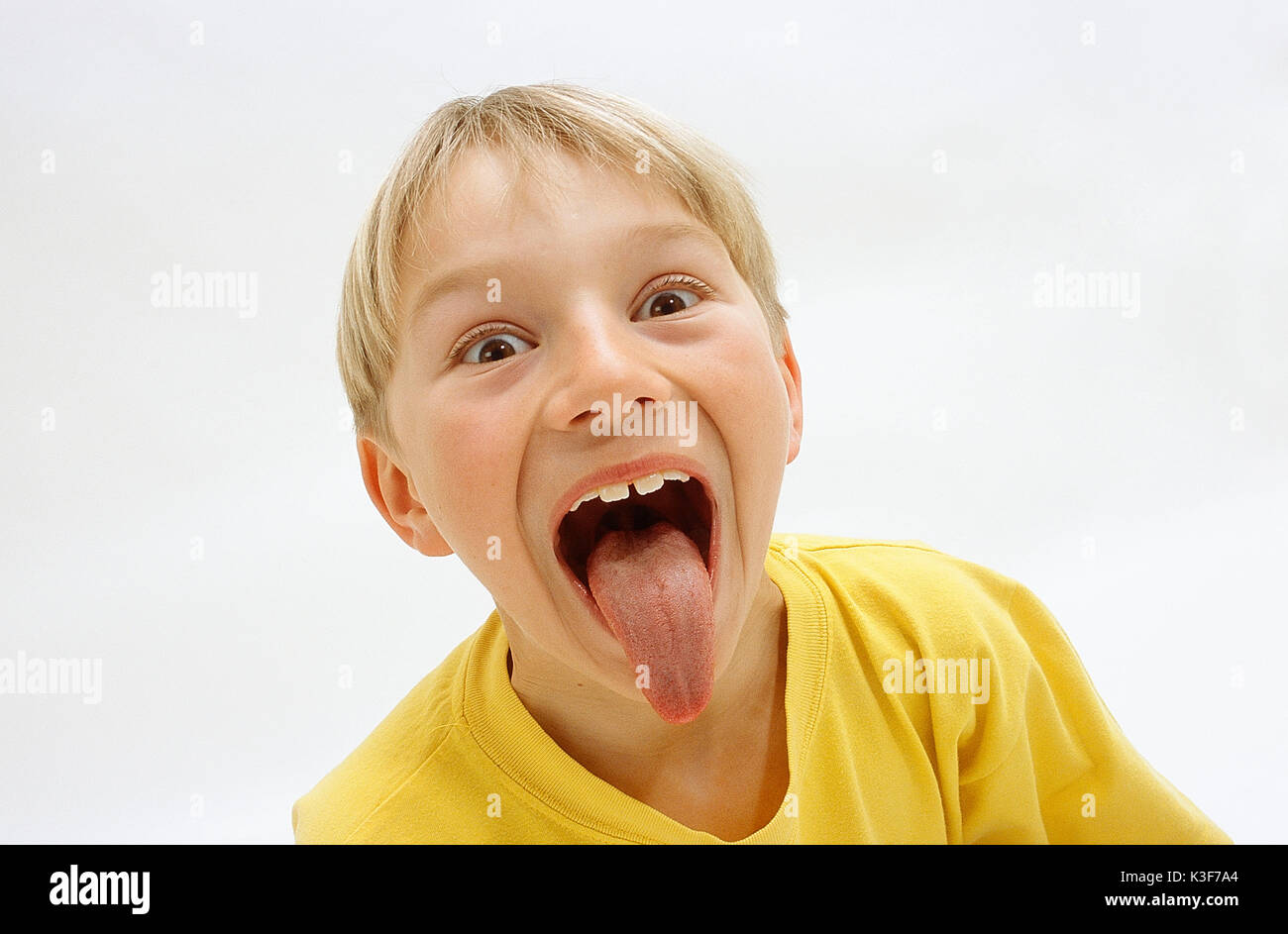 Blonde junge klebt die Zunge Stockfoto