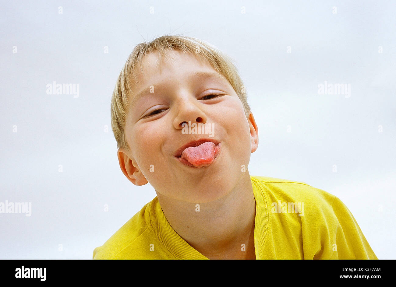 Blonde junge klebt die Zunge Stockfoto