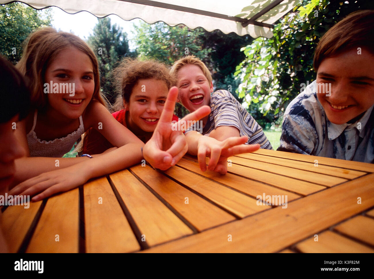 Gruppe Kinder/Jugendliche um einen Tisch Stockfoto