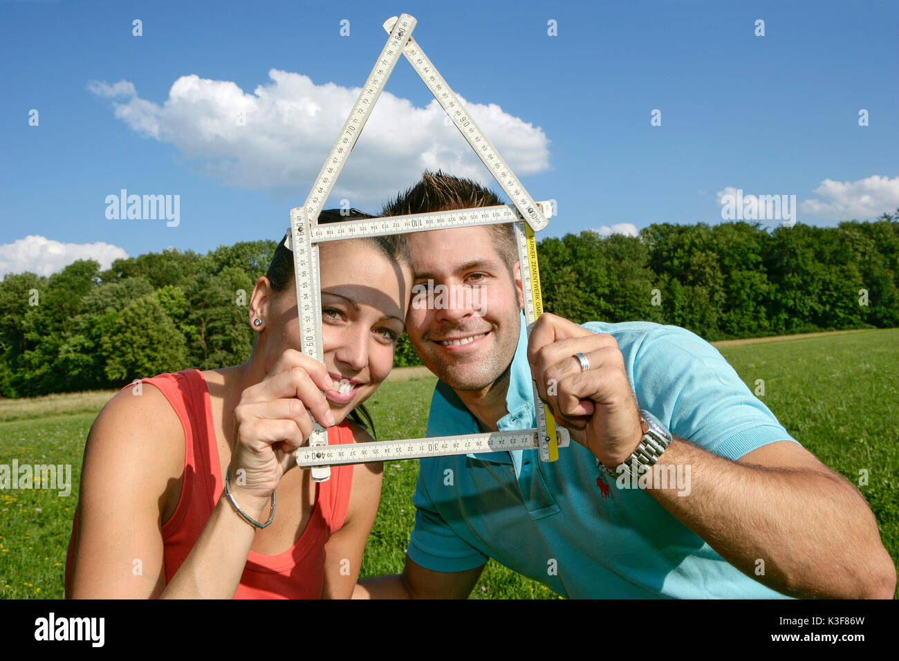 Junge paar plant Bau eines Hauses im Grünen und Formen Haus von einem Yard stick Stockfoto