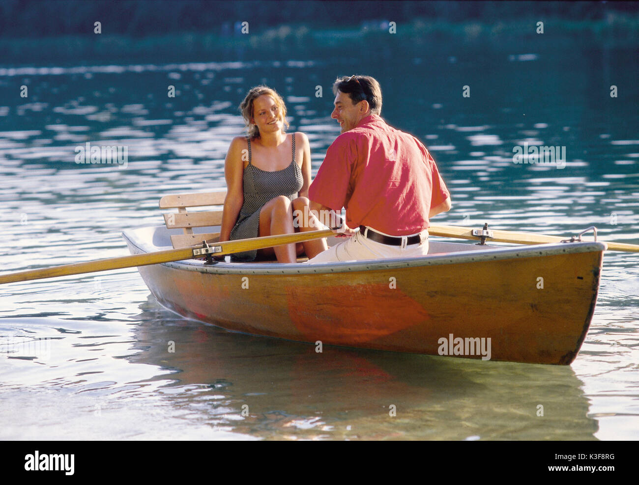 Paar an einer romantischen Bootsfahrt mit einem Ruderboot auf einem See Stockfoto