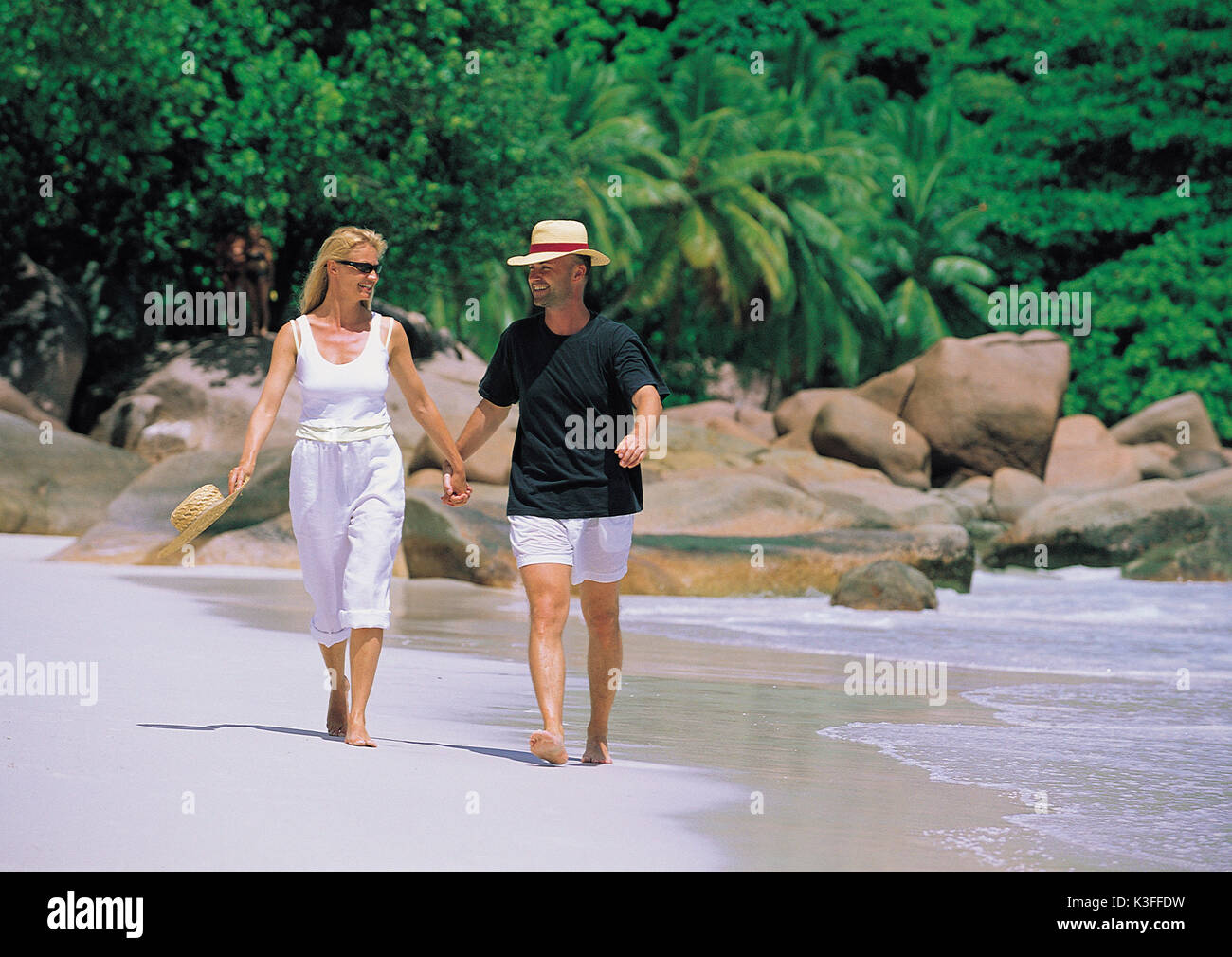 Paar geht für einen Spaziergang hand in hand am Strand Stockfoto