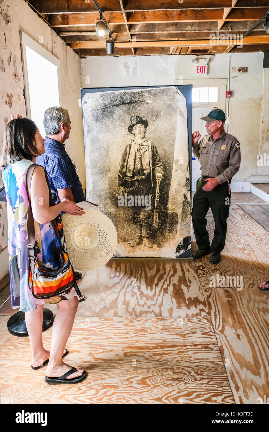 Ein Park Ranger erzählt Geschichten von Billy the Kid vor einem großen Billy the Kid Bild am historischen Lincoln County Court House, Lincoln, New Mexico, U Stockfoto