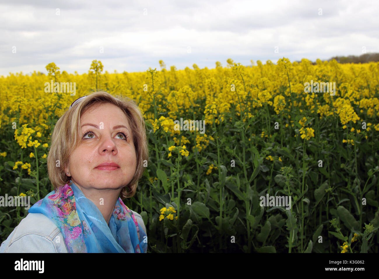 Junge blonde Frau auf einem Raps Feld Stockfoto