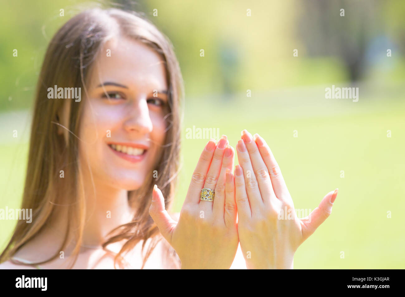 Porträt der jungen schönen Frau mit langem Haar zeigt schöne Nägel an Händen Stockfoto