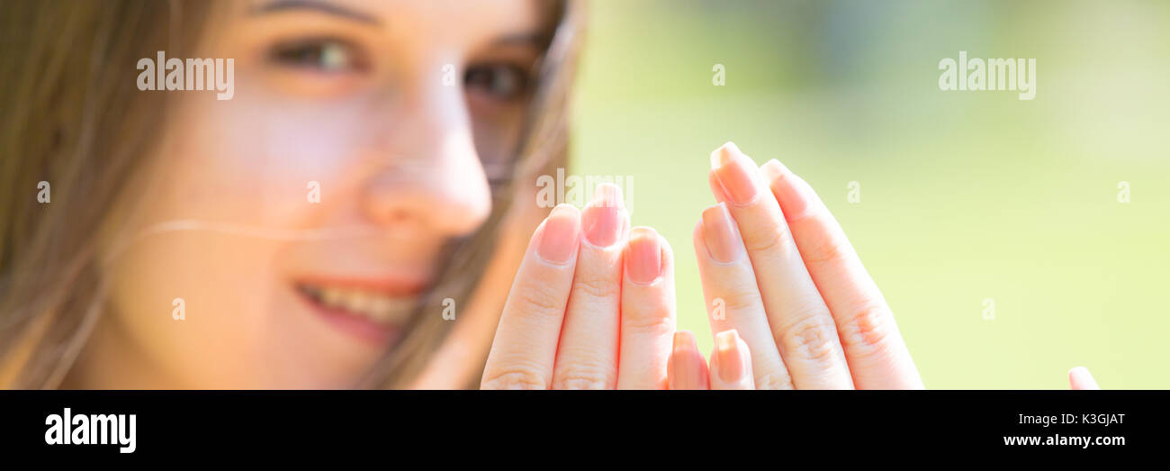 Porträt der jungen schönen Frau mit langem Haar zeigt schöne Nägel an Händen Stockfoto