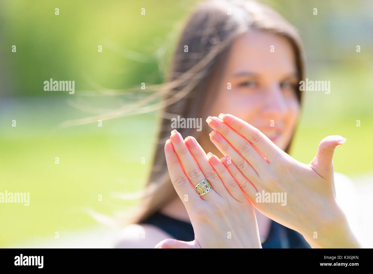 Porträt der jungen schönen Frau mit langem Haar zeigt schöne Nägel an Händen Stockfoto