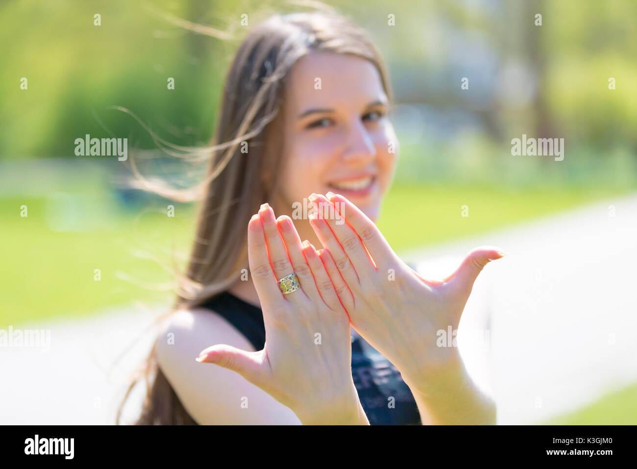 Porträt der jungen schönen Frau mit langem Haar zeigt schöne Nägel an Händen Stockfoto