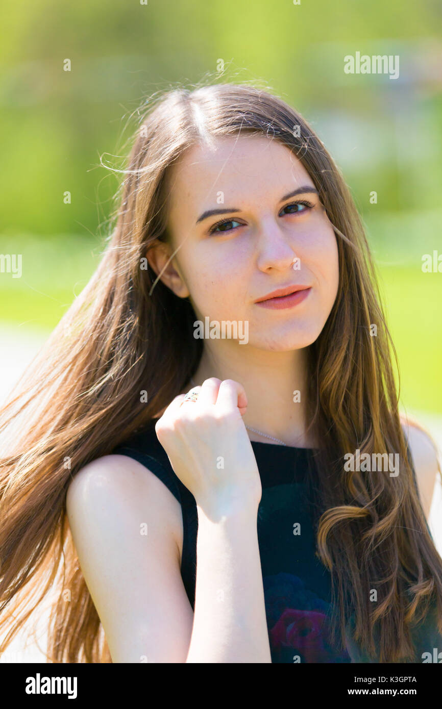 Porträt der jungen schönen Frau mit langen Haaren in grün Spring Park Stockfoto