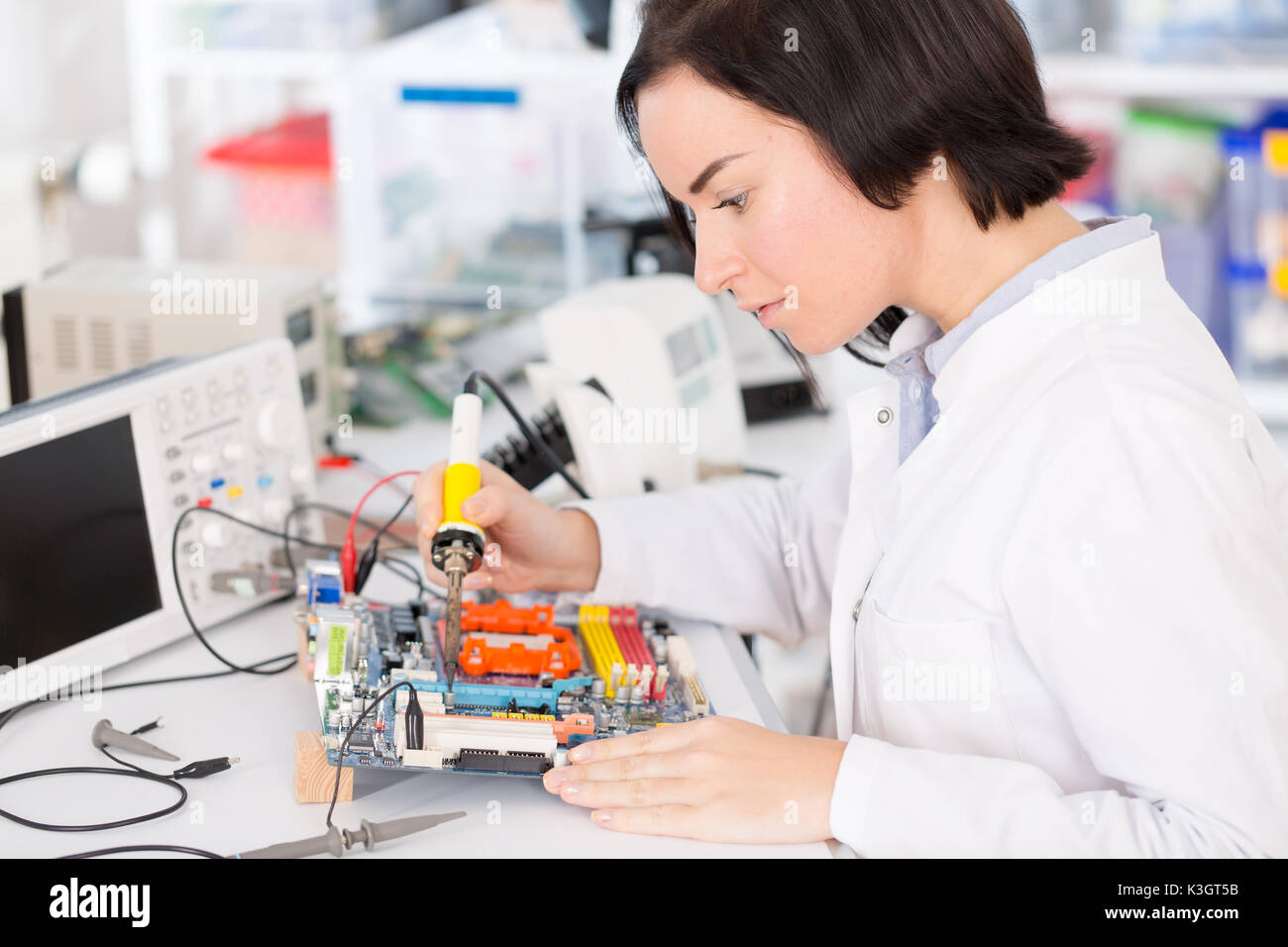 Weibliche Laboratory Assistant Reparaturen PCB-Modul für CNC Robotik. Messung der Parameter der elektronischen System im Labor Stockfoto