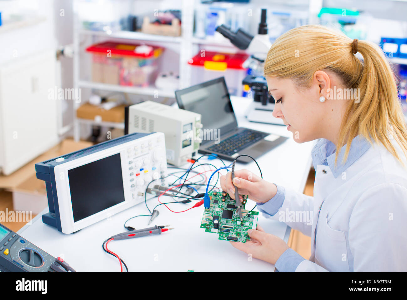 Weibliche Laboratory Assistant Reparaturen PCB-Modul für CNC Robotik. Messung der Parameter der elektronischen System im Labor Stockfoto