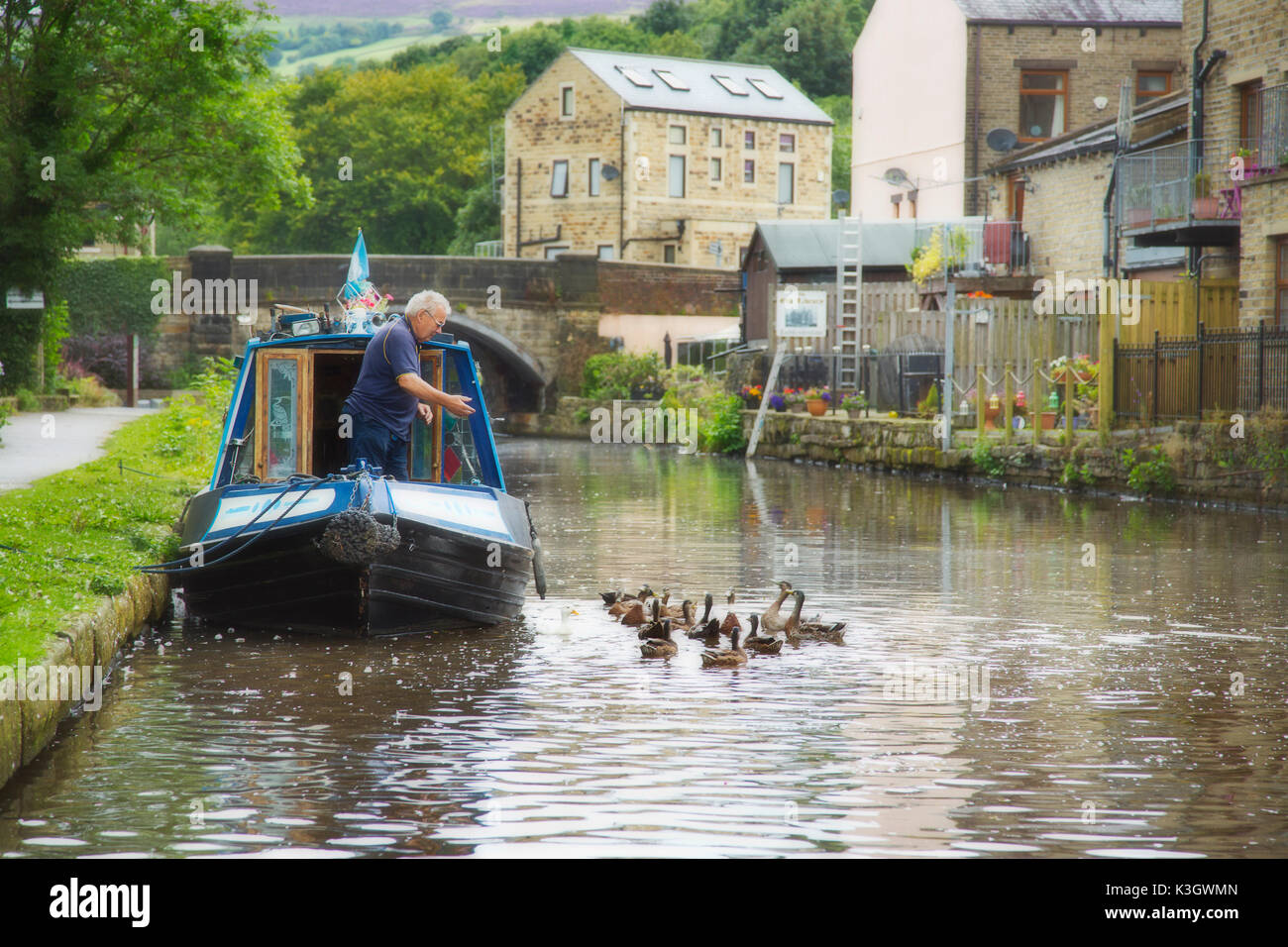 Ein Mann Füttern der Enten am Rochdale Kanal, West Yorkshire, England Stockfoto
