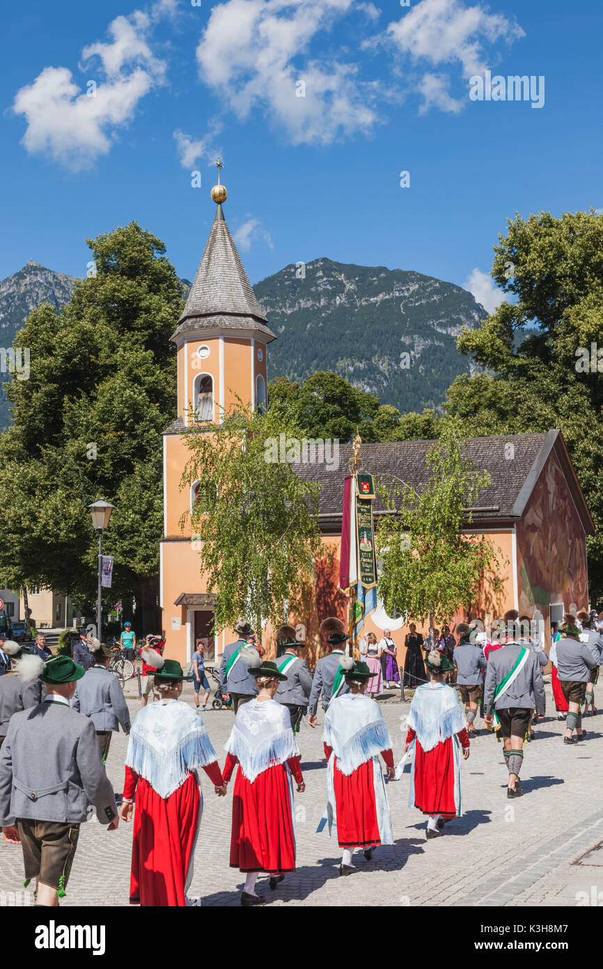 Deutschland, Bayern, Garmisch-Partenkirchen, Bavarian Festival gruppieren in Tracht marschiert und Kirche Stockfoto