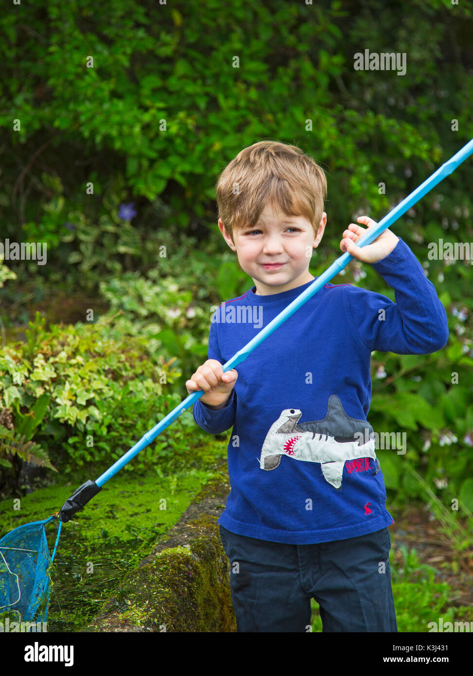 Ein kleiner Junge mit einem Fischernetz Stockfoto