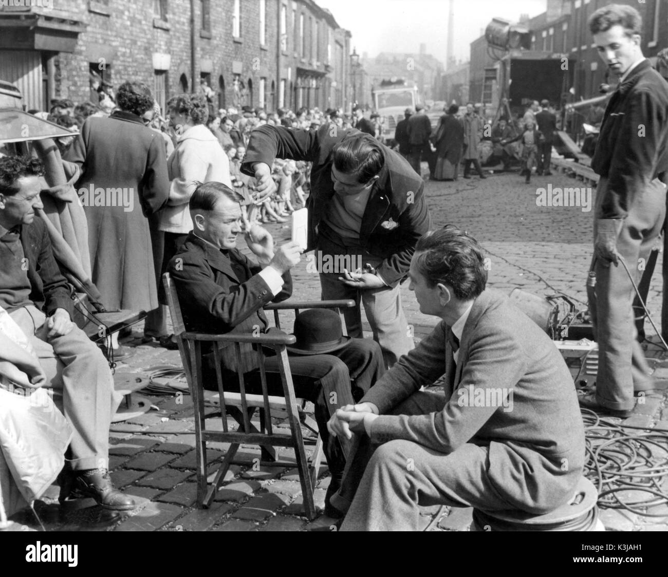 Schauspieler JOHN MILLS [Stuhl] prüft seine Erscheinung, von Regisseur David Lean [Direkt] beobachtete, während vor Ort für HOBSON'S CHOICE [BR 1954] Stockfoto