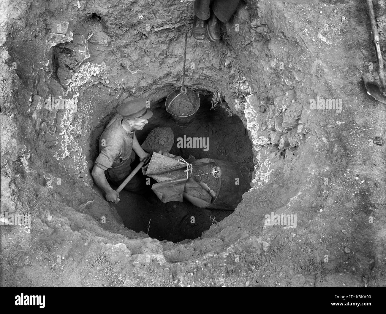 Gefährliche Arbeit! Eine Bombenentschärfung officer Graben eine nicht explodierte deutsche Bombe in London 1943 Stockfoto