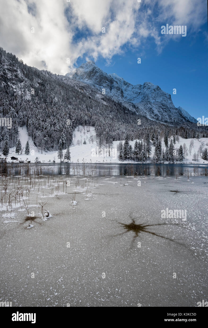 Eis in der ferchensee über Mittenwald, Blick auf den See und die schneebedeckten Wettersteingebirge, der Schnee auf dem Berg spiegelt das Blau des Himmels. Stockfoto