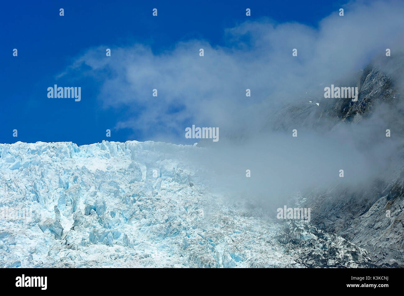 Teile der Fox Glacier in Neuseeland mit tief hängenden Wolken und Kamm. Stockfoto