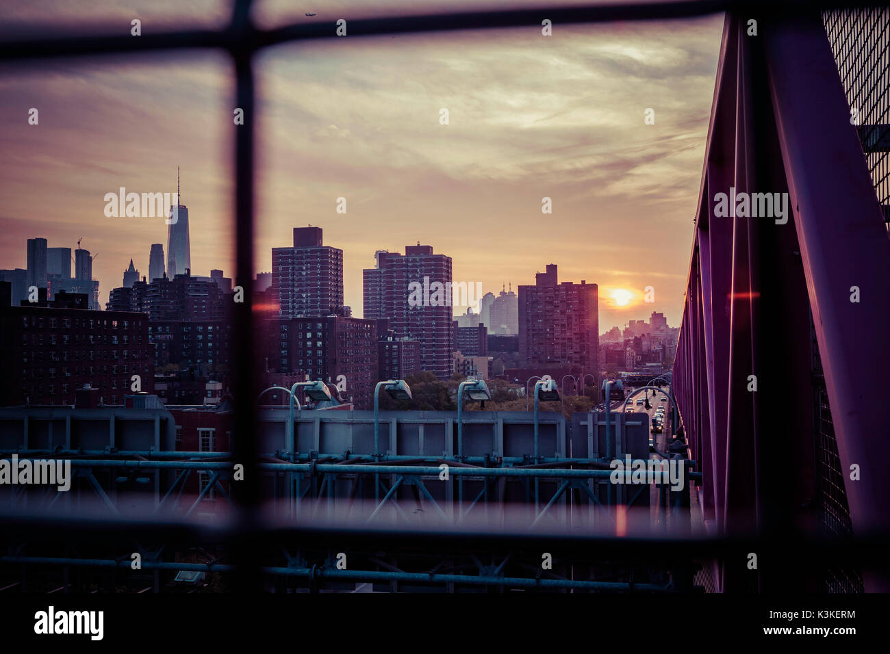 Sonnenuntergang und Endzeitpunkt auf die Williamsburg Bridge, von Manhatten Skyline durch Raster, New York, USA Stockfoto