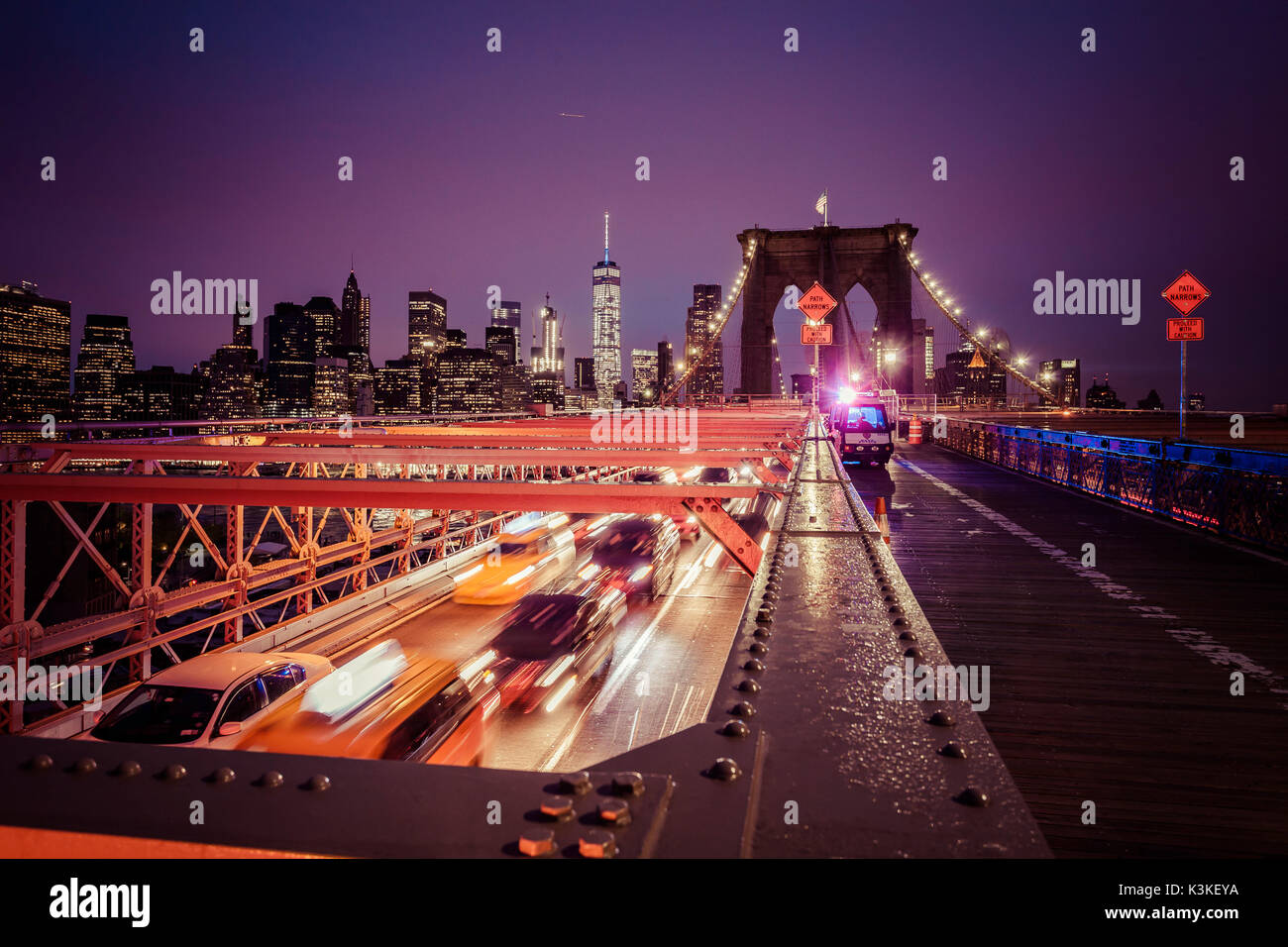 Der Verkehr auf der Brooklyn Bridge, regnerischen Abend, Wolkenkratzer und Skyline von Manhatten, New York, USA Stockfoto