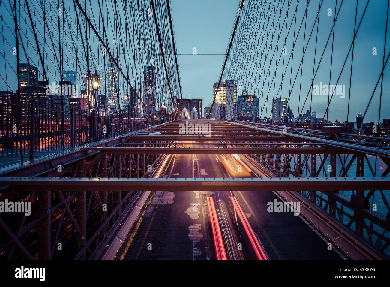 Der Verkehr auf der Brooklyn Bridge, regnerischen Abend, Wolkenkratzer und Skyline von Manhatten, New York, USA Stockfoto